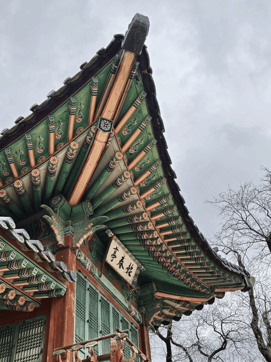 Traditional Korean temple roof against a cloudy sky