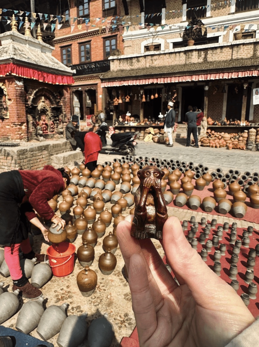Hand holding a small bell at a market stall